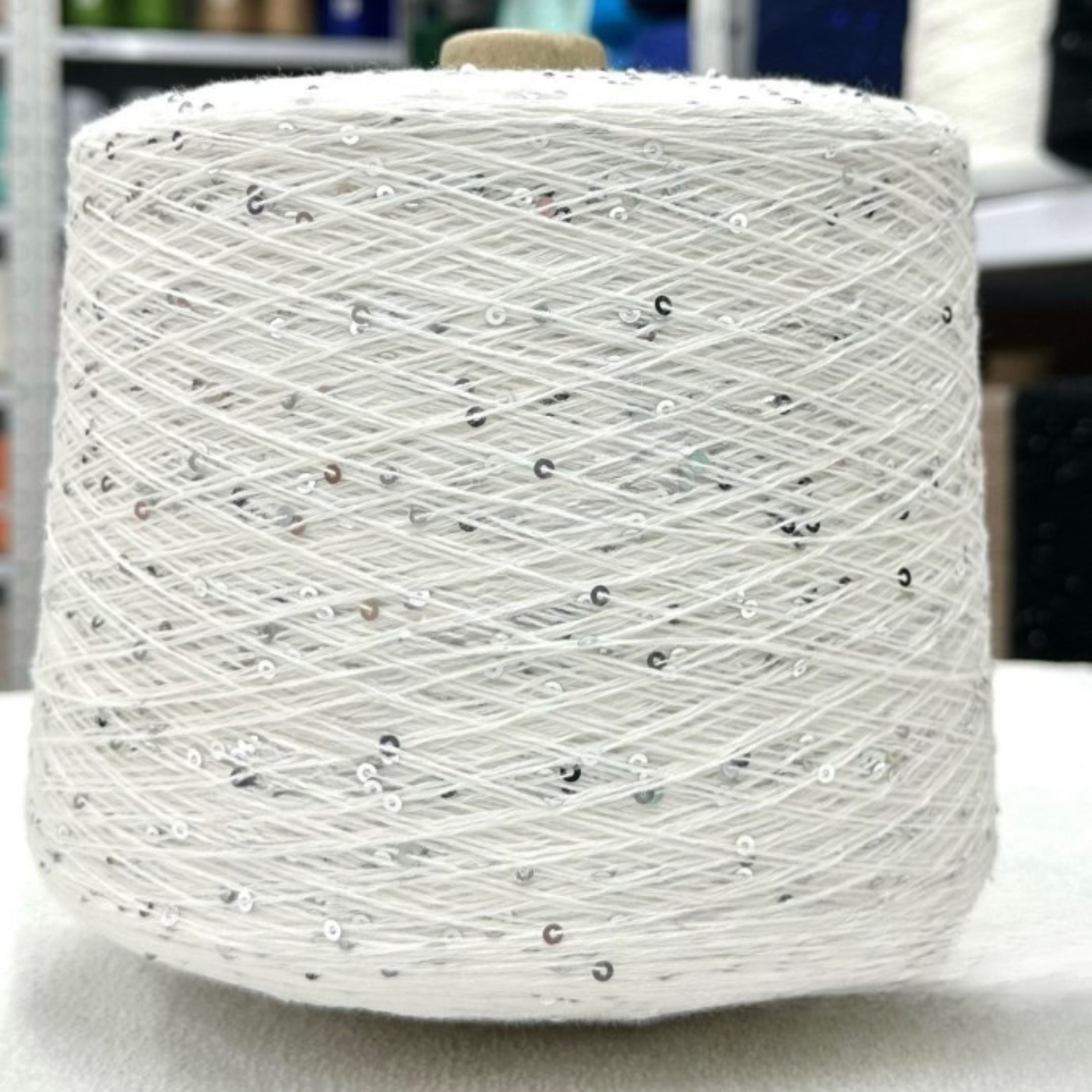 Sparkling yarn skein next to crochet hook