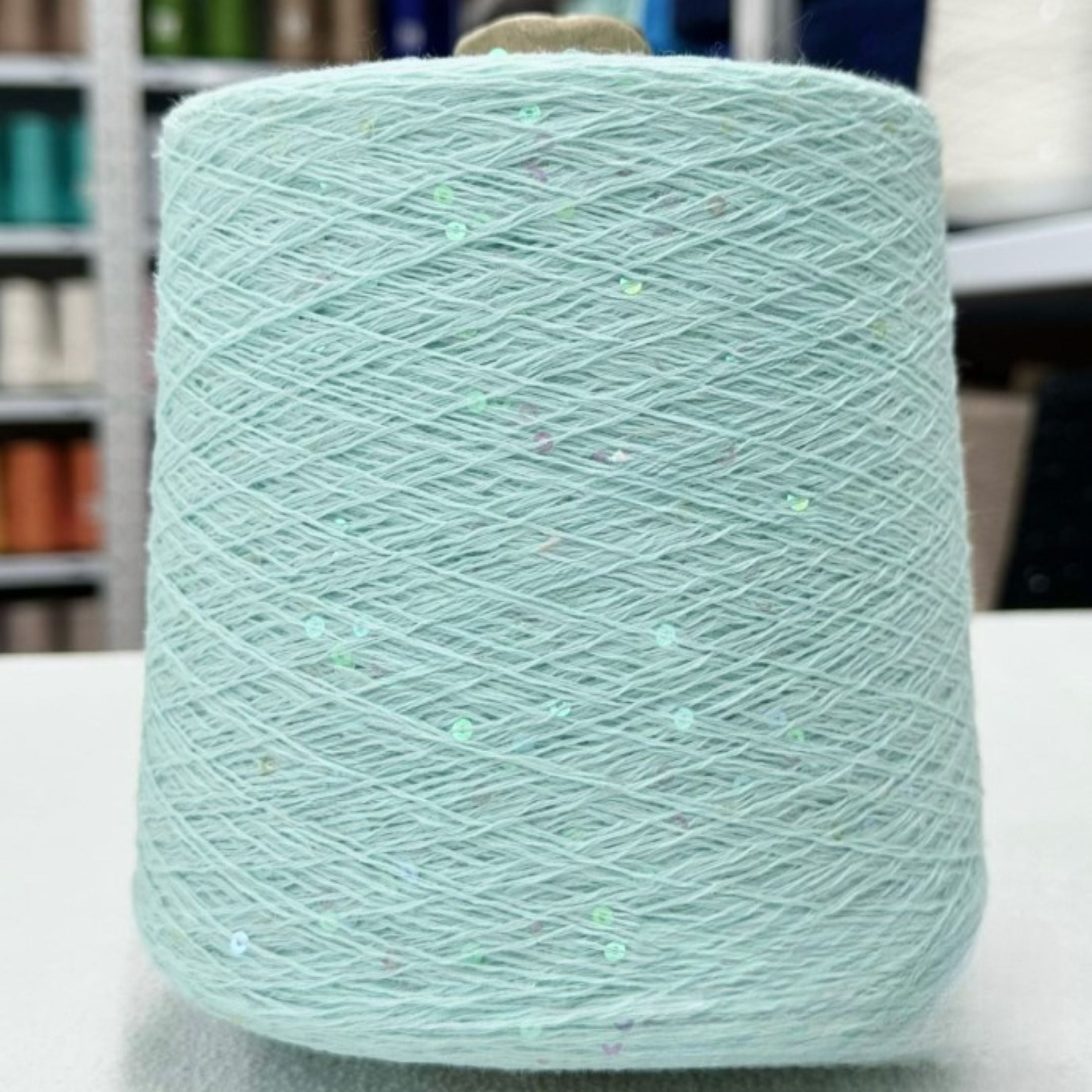 Close-up of shimmering sequins on soft cotton thread