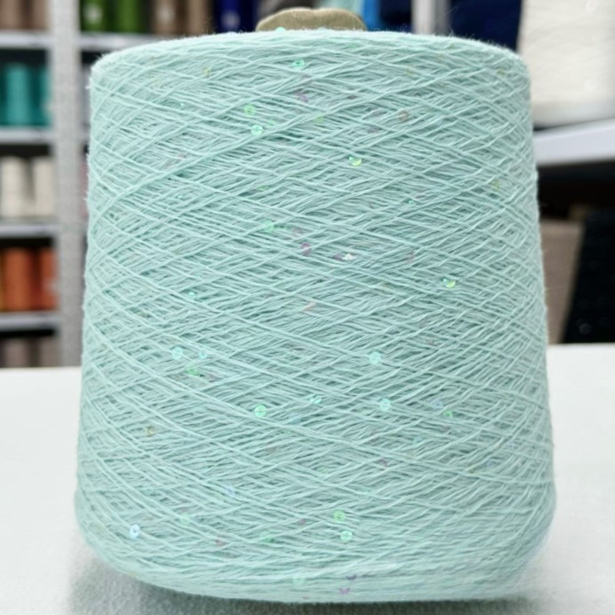 Close-up of shimmering sequins on soft cotton thread