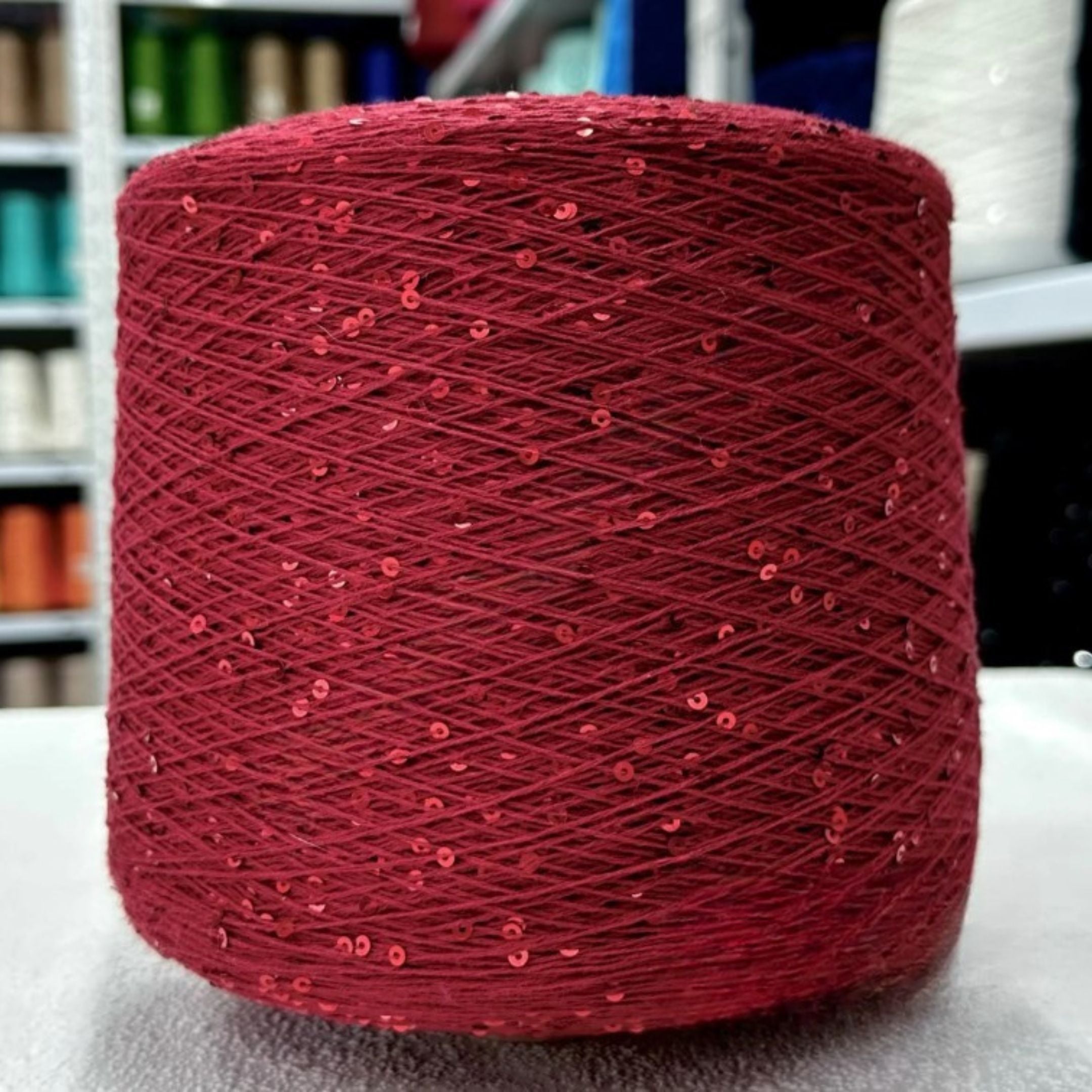 Hand holding soft sparkling 3mm sequin cotton yarn