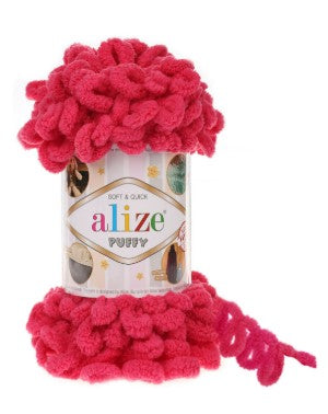 Red yarn ball on a can of Alize Puffy yarn with a white background