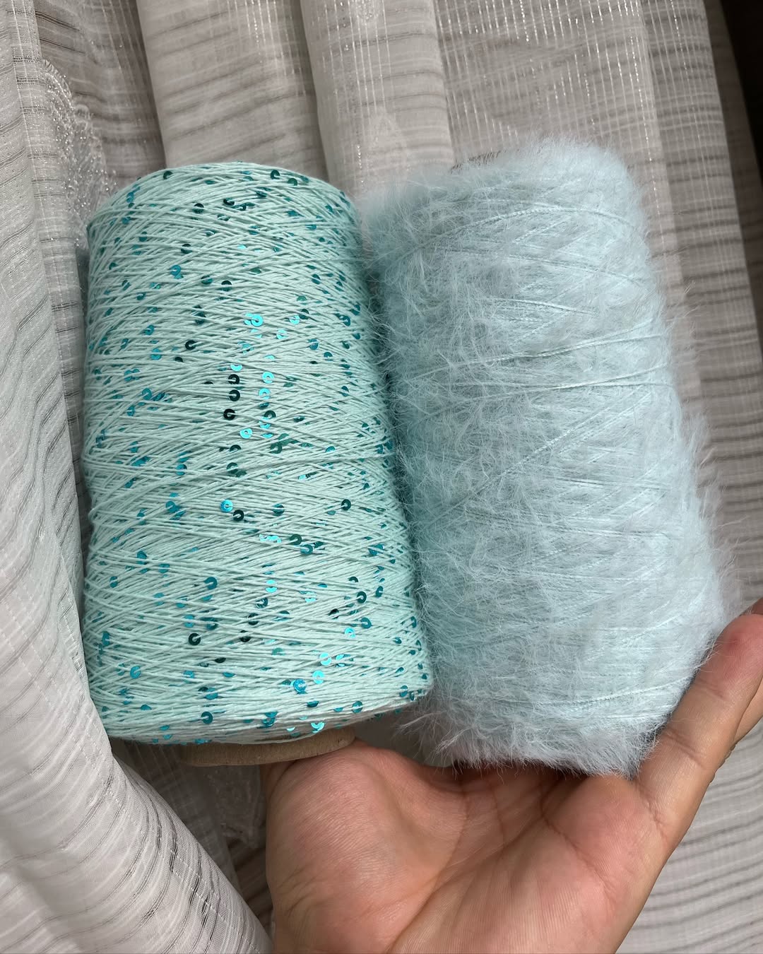 Female palm showcasing shimmering cotton yarn skein