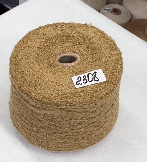 Brown yarn spool with a label on a white surface fluffy boucle skeins from Italy – soft shades