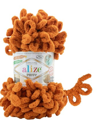 Orange yarn ball with a label on a white background alize puffy 234