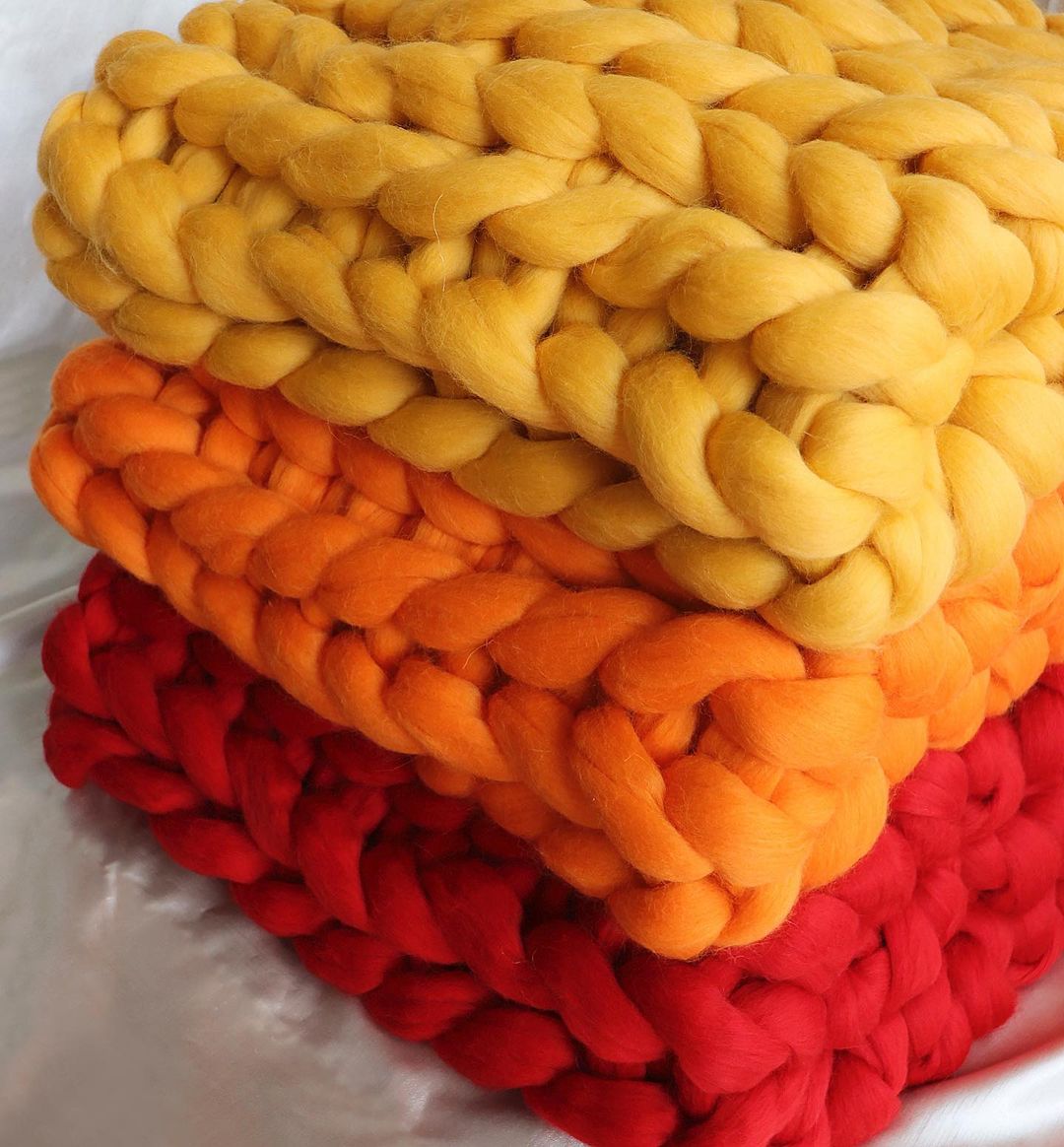 Oatmeal 20x50 arm-knit blanket rolled on bench