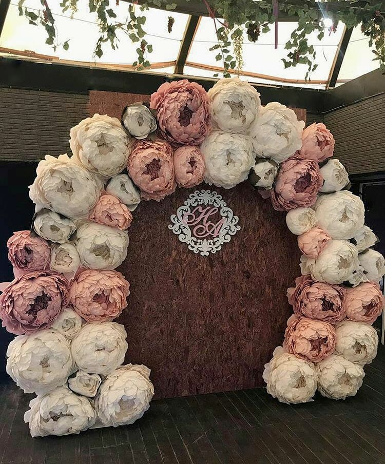 Decorative wreath with pink and white flowers on a wooden board.