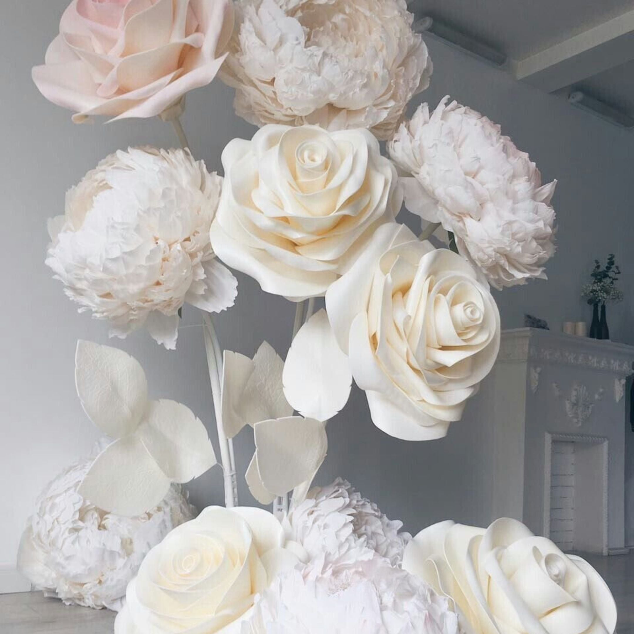 Giant paper peony and rose composition in soft ivory and blush tones, handmade oversized flowers close-up, wedding decor detail