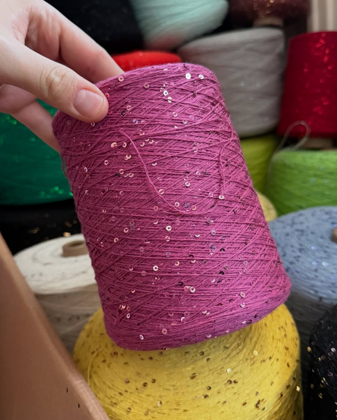 Soft sparkling yarn resting on open hand