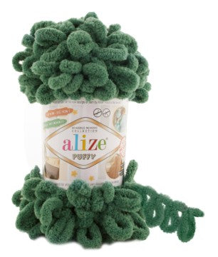 Green pom-pom toy on top of a container labeled 'alize puffy 532' with a white background