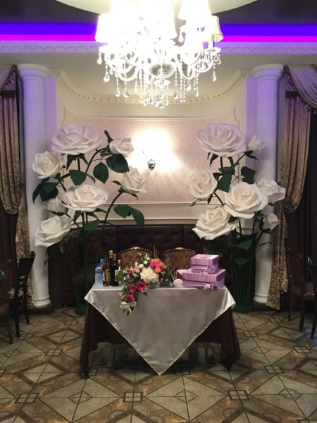 Oversized ivory giant foam roses around sweetheart table setup, luxury foam wedding lounge centerpiece with gifts and romantic ambiance