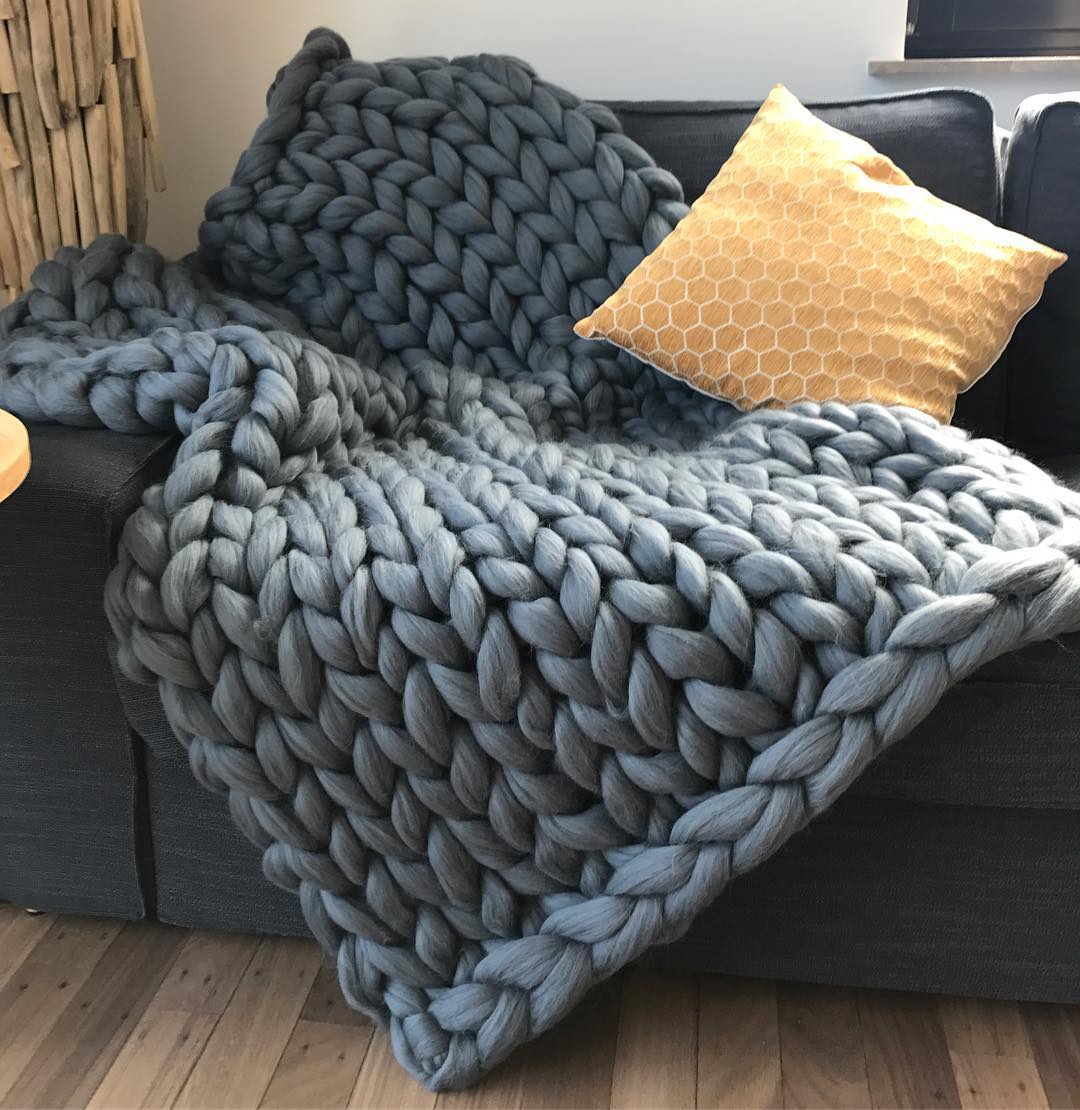 Chunky merino wool arm-knit blanket on bed