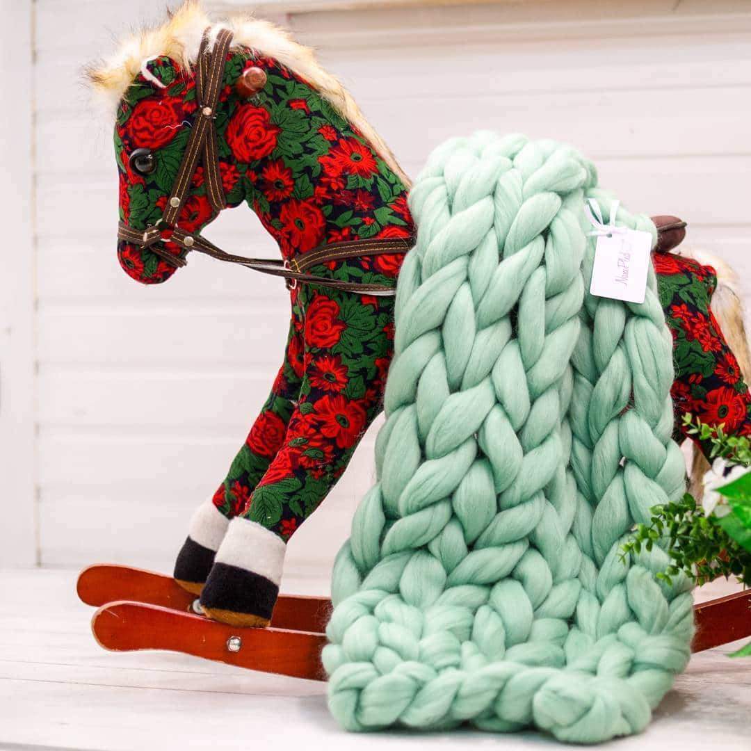 Close-up detail of hypoallergenic Merino wool chunky knit texture, highlighting plush, pilling-resistant fibers in Forest Green – perfect for luxury home comfort.